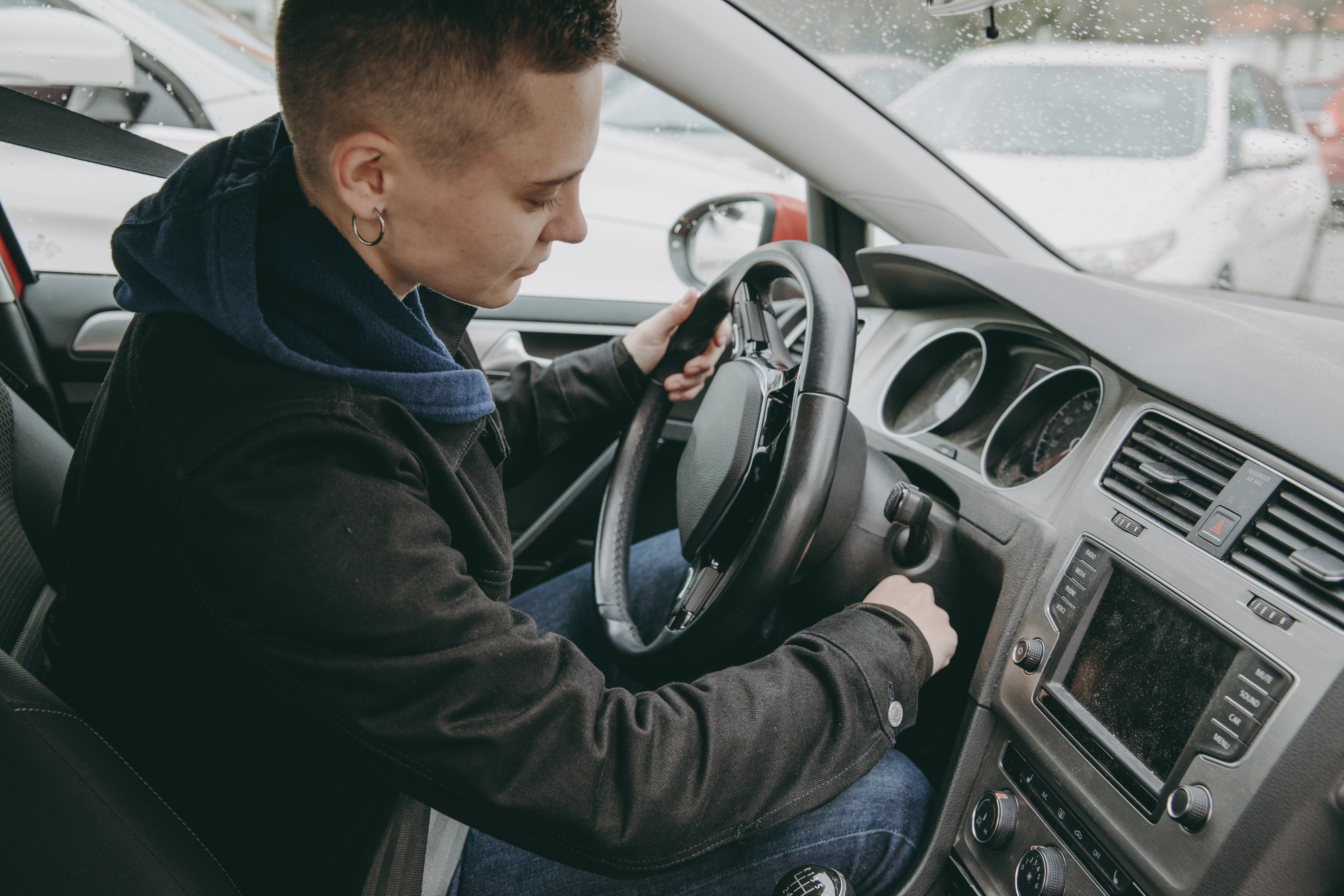 Fokusert person vrir om nøkkelen for å starte bilen og forbereder seg på en sikker kjøretur.